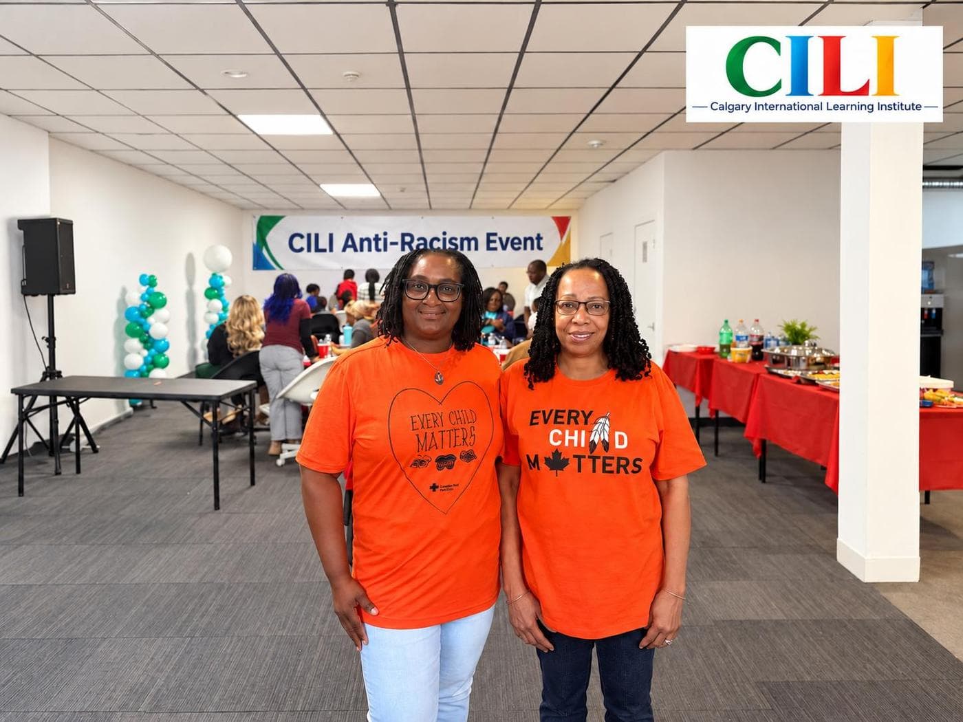Two women wearing orange Every Child Matters shirts smiling together at the CILI Anti-Racism Event.