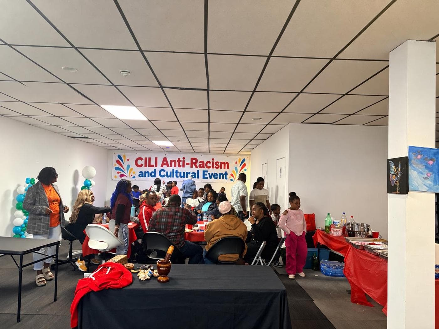 Families and community members gathered around food tables at the CILI Anti-Racism and Cultural Event.
